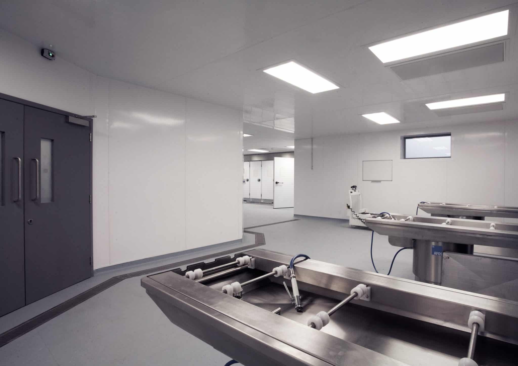 Stacked white rigid PVC cladding sheets showing smooth surfaces and straight edges